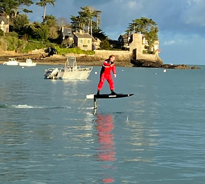 Mann schwebt mit E–Foil Board über das Wasser